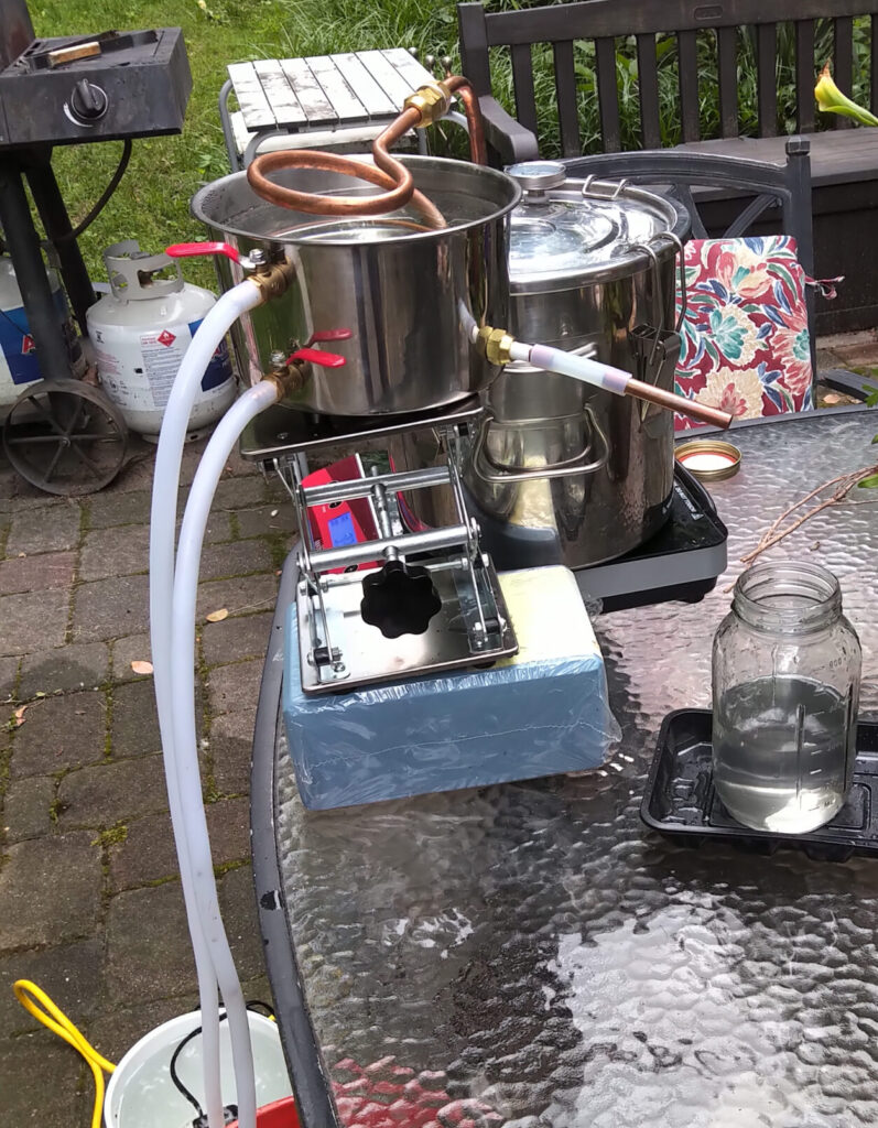 A DIY water filtration setup on a glass table outdoors.