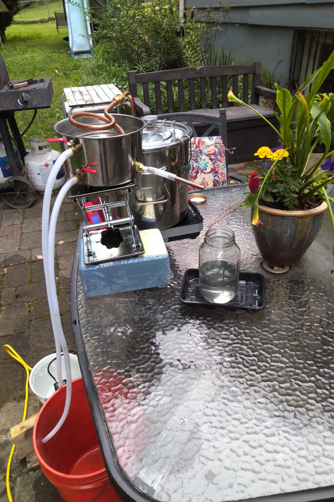 A DIY water filtration setup on a glass table outdoors.