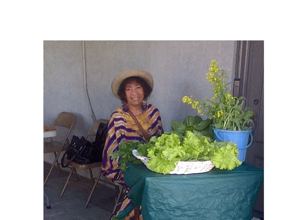 Woman selling fresh vegetables at an outdoor market.