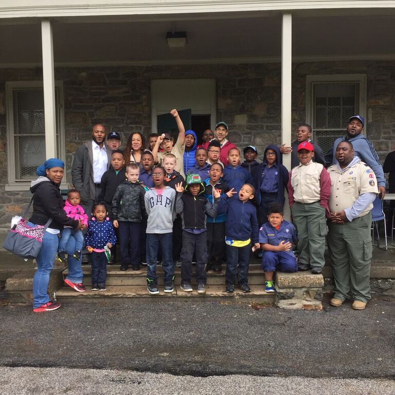 Group of children and adults posing together outside a building.