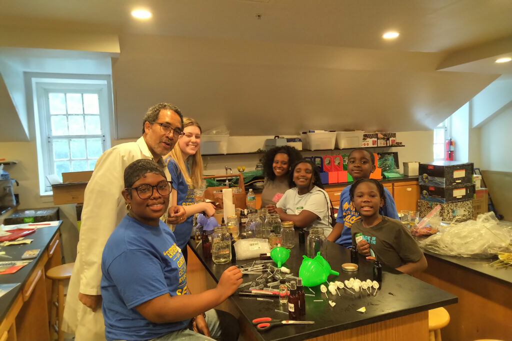 A diverse group enjoys a science activity in a bright classroom.